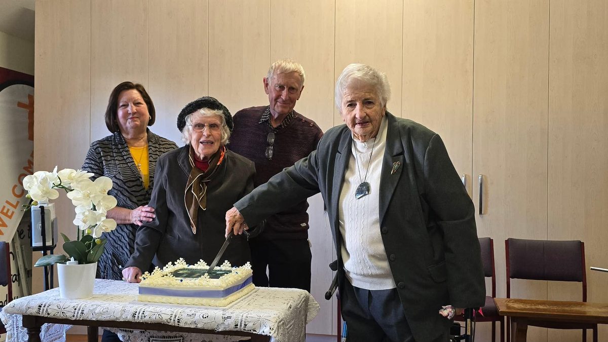 A society gathering with a celebration cake being cut