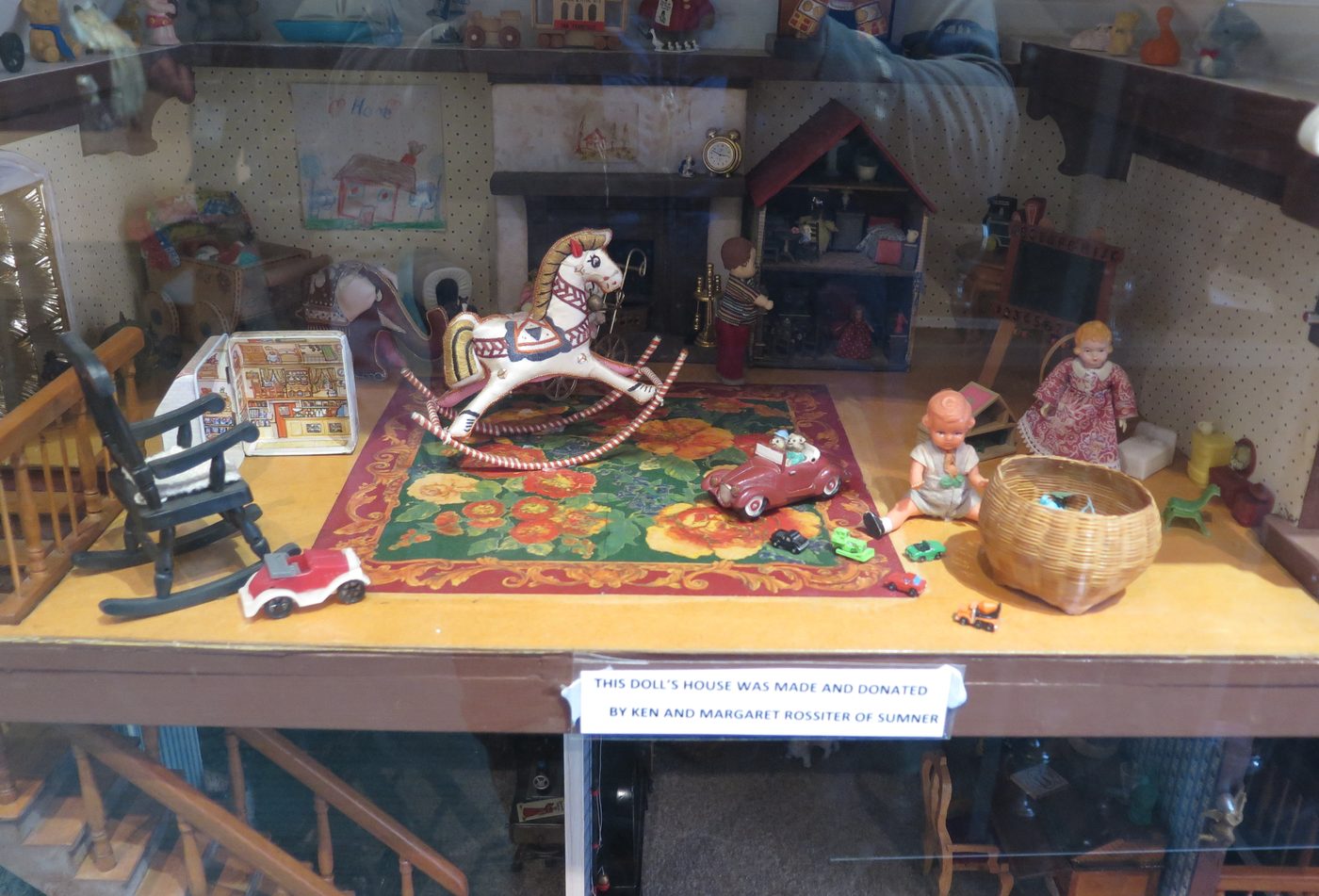 Display of historical toys including a rocking horse, dolls and a toy car